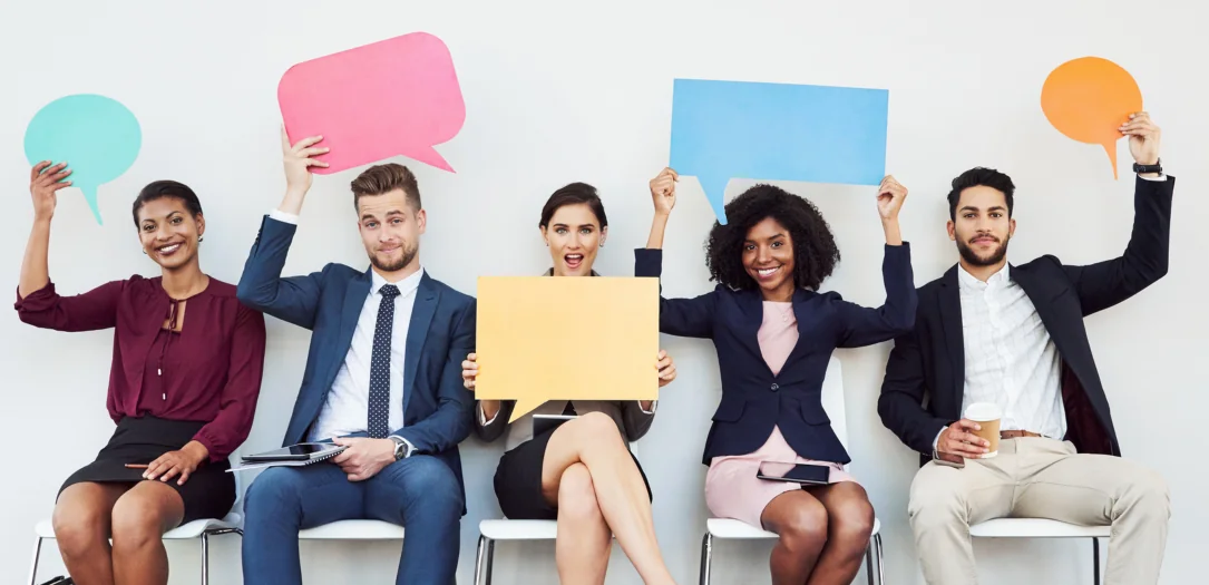 Symbolbild Mitarbeiterbindung: Mitarbeiter:innen halten Sprechblasen in die Luft